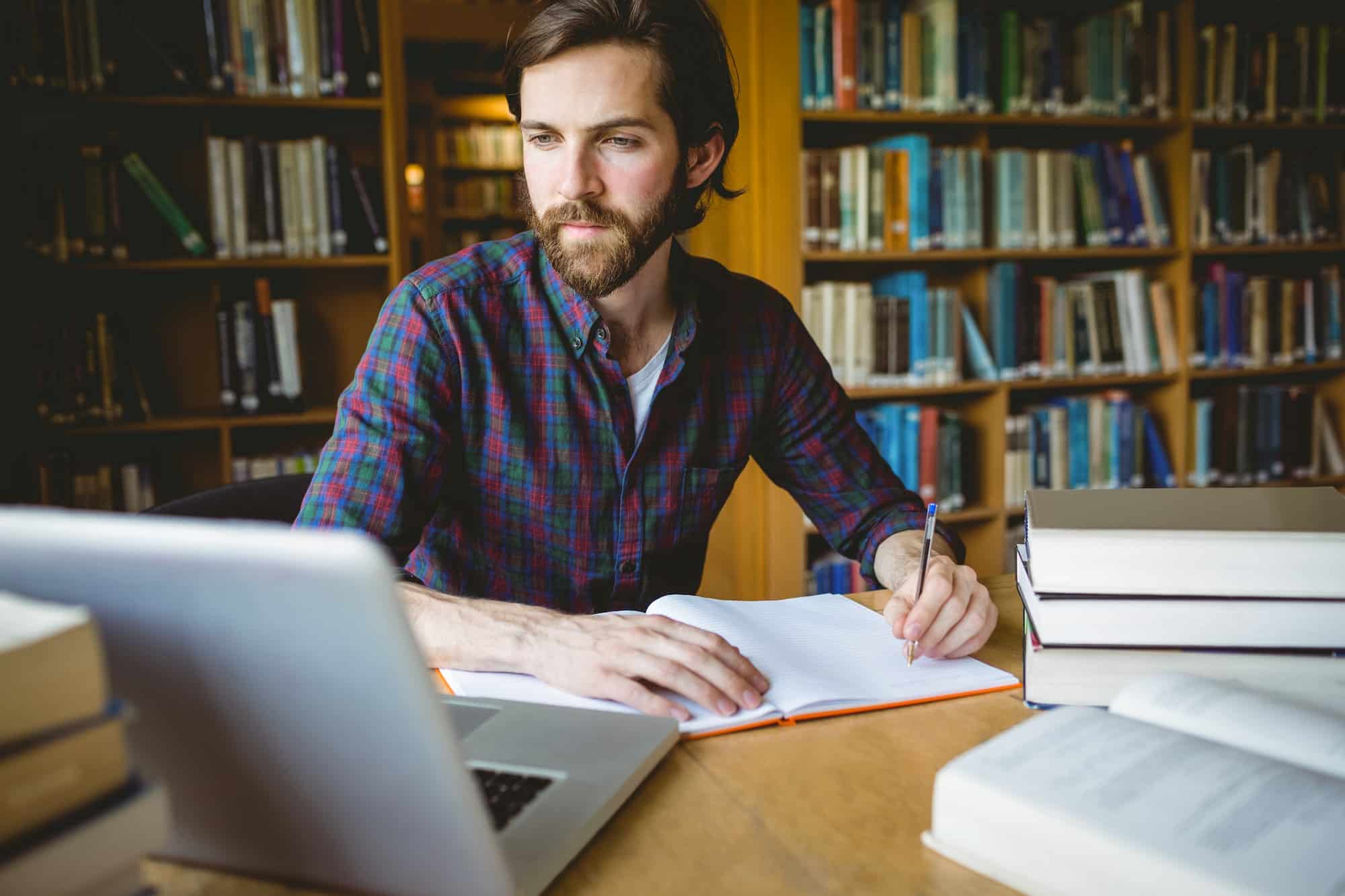 Hipster student studying in library at the university