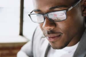 homme portant des lunettes en train de relire un texte